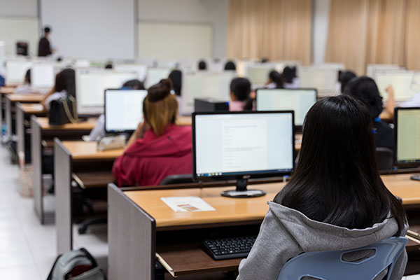 Large classroom of students on computers learning